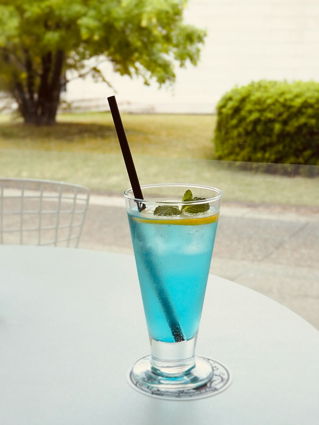 Bebida azul helada con limón y menta sobre una mesa.