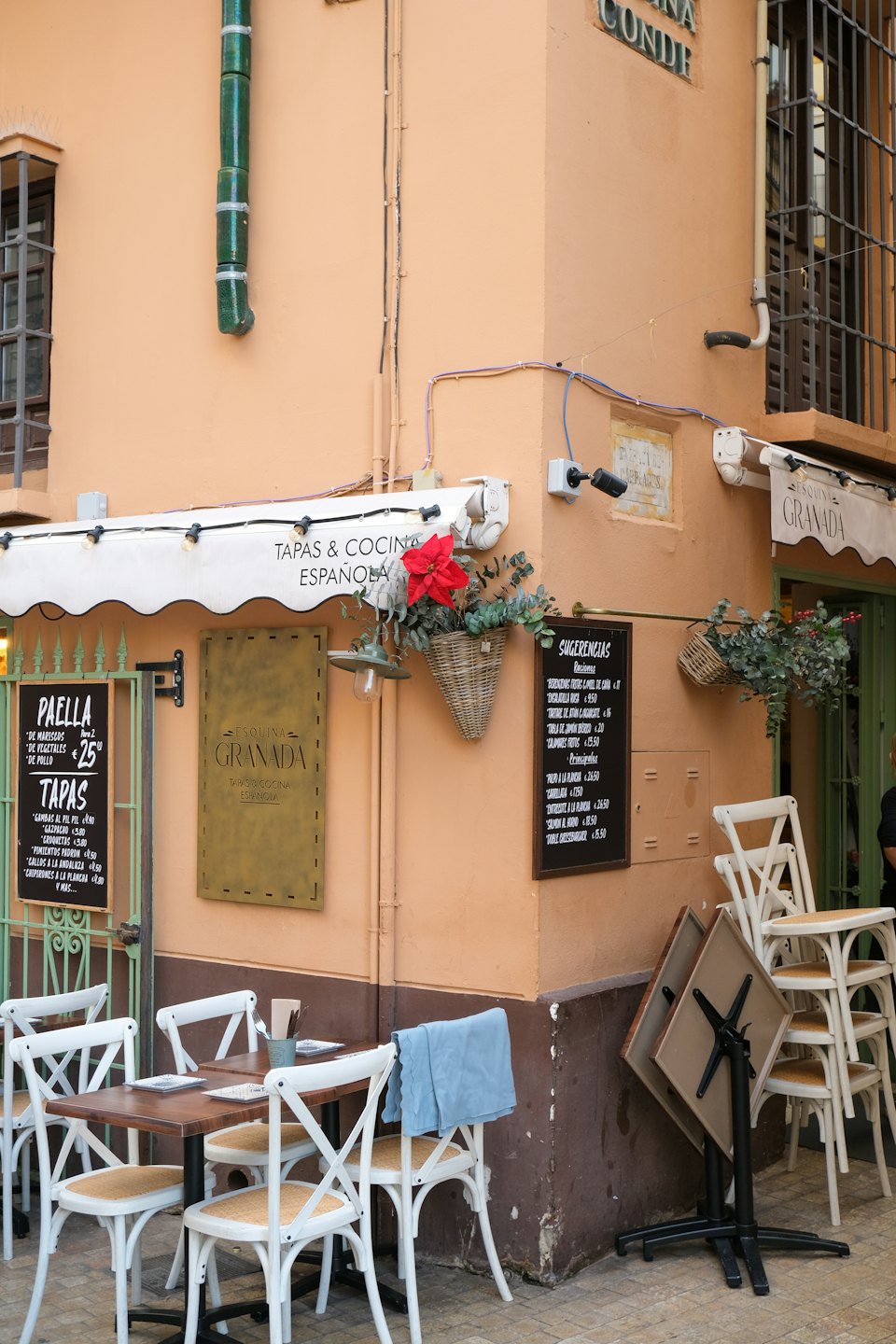 Zona de comedor exterior de un restaurante español con suelo de baldosas.