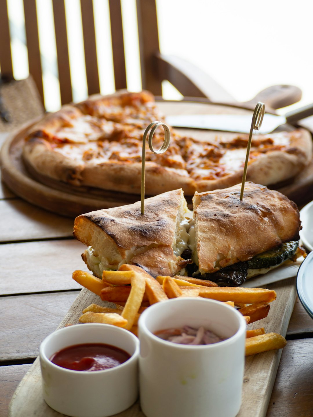 Tabla de bocadillos gourmet con patatas fritas y guarniciones.