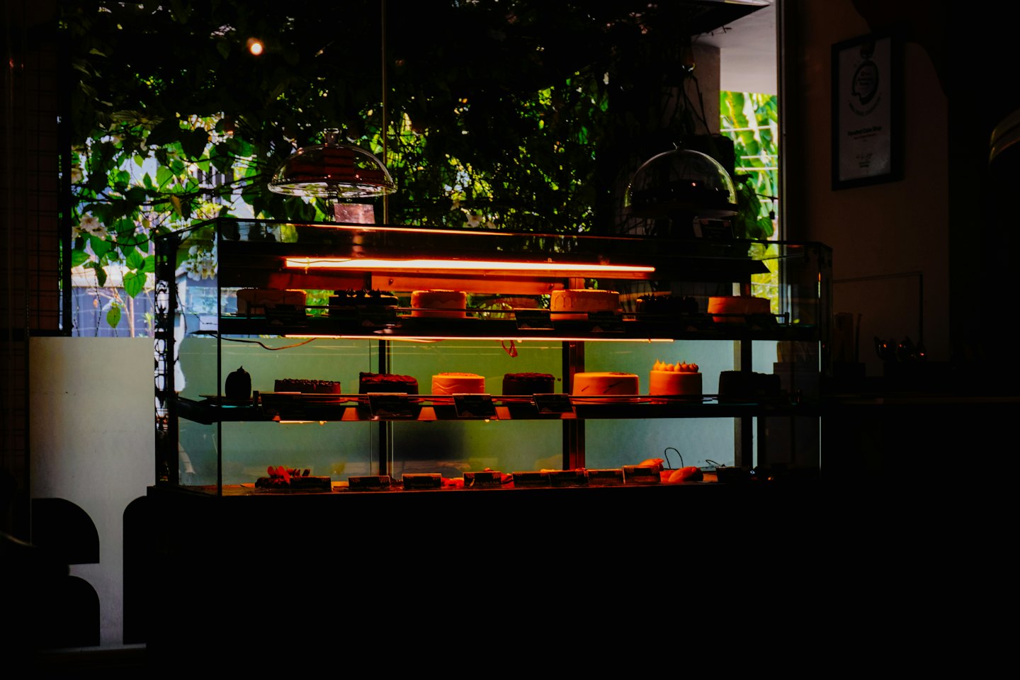 Vitrina de cristal llena de pasteles y tartas en una cafetería.